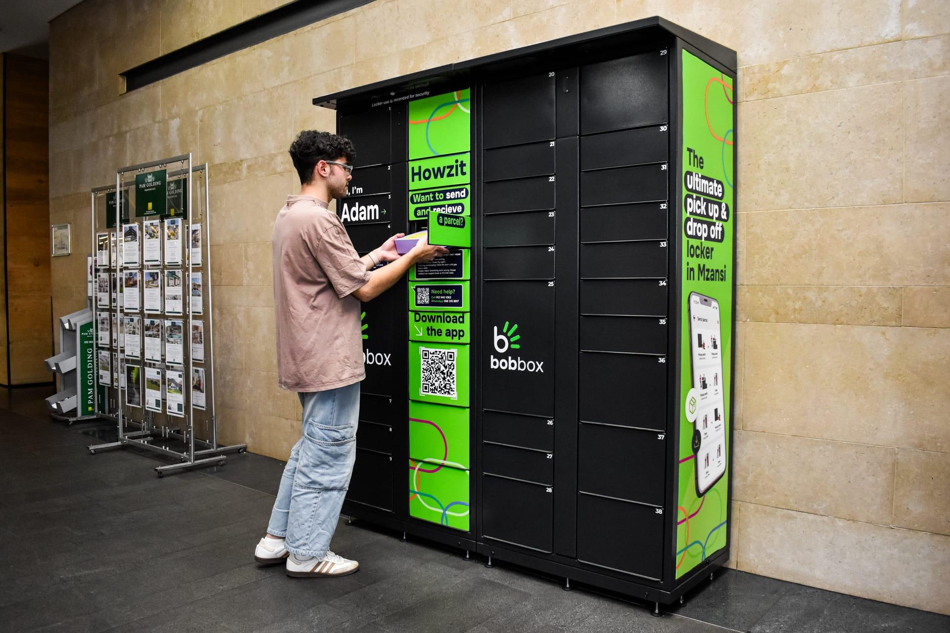 A customer sends a parcel at a Bob Box locker bank inside a building foyer.